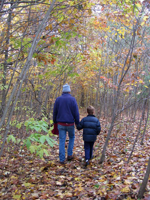 Tom Montgomery Fate walking in an autumn woods with his son